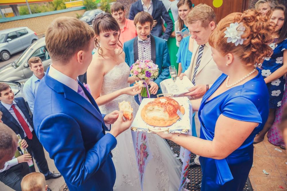 Встреча молодых с караваем на свадьбе: кто должен держать свадебный хлеб, соль и икону, какие слова говорят родители молодоженам во время обряда